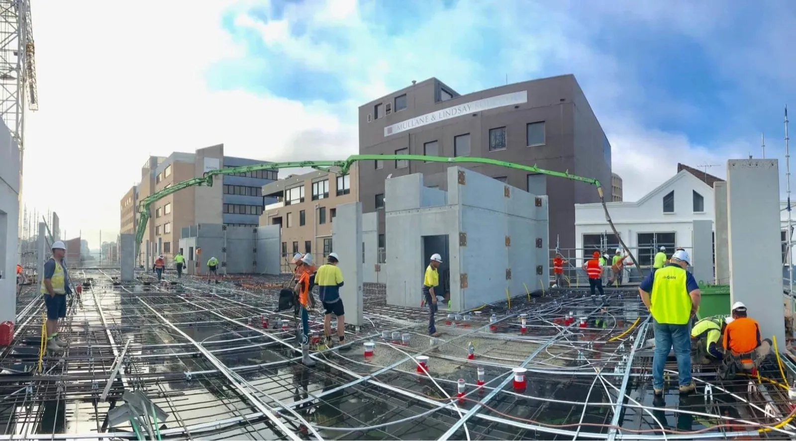 A concrete boom pump reaching across a large warehouse slab pour